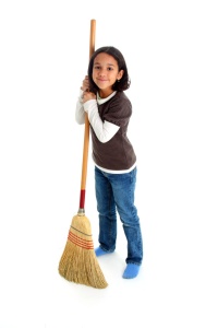 Girl cleaning the house with a broom